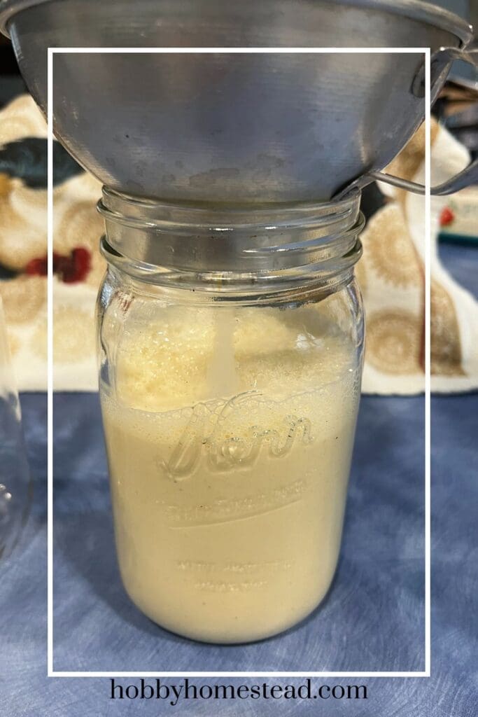 Filling a glass jar with eggnog to cool
